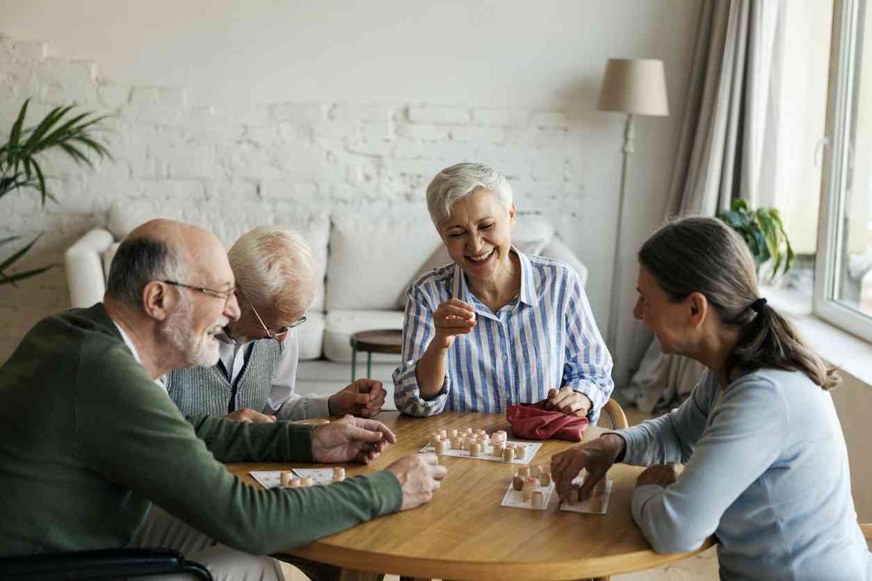 Positive elderly people spending time together at home, using